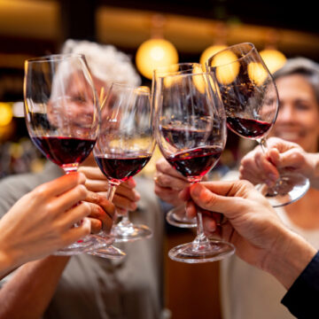 Close-up on a happy group of people making a toast at a wine tasting