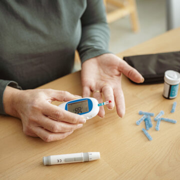 Mature diabetic woman using glucometer for checking blood sugar level at home. High resolution 42Mp indoors digital capture taken with SONY A7rII and Zeiss Batis 40mm F2.0 CF lens